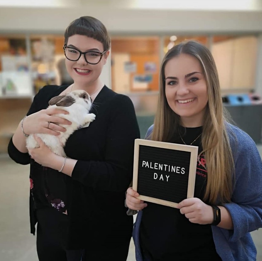 Sam holding a bunny from Human Society with Jess holding Palentine's Day sign