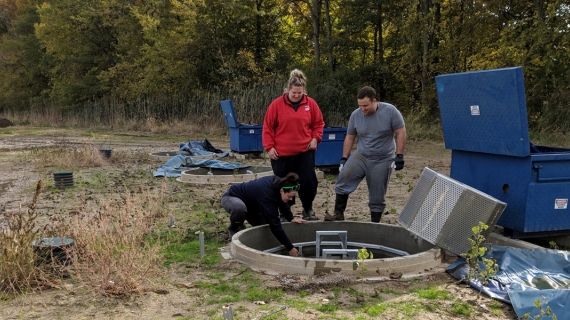 Watershed research technicians Mackenzie Porter and Samantha Dundas of the Essex Region Conservation Authority and biochemistry student Dave Ure clear a biofilter at the Lebo Creek Wetland.
