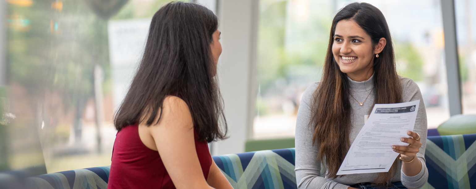 Two female students reviewing a resume