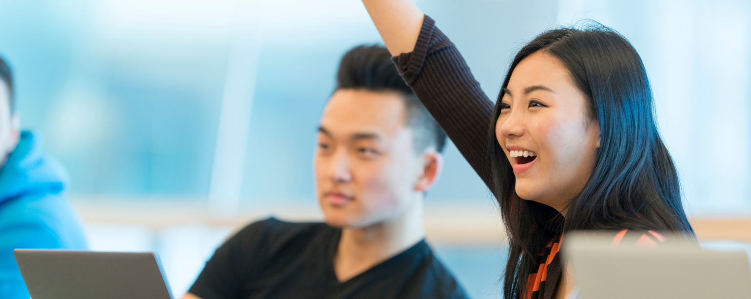 Female student raising her hand at a workshop.