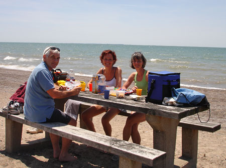 Alan Wright, Marianne Poumay and Marie-Jeanne Monette sitting at picnic table.