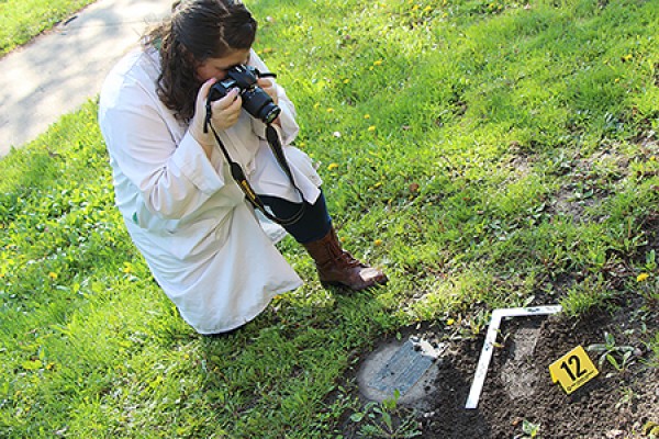 student photographing muddy footprint