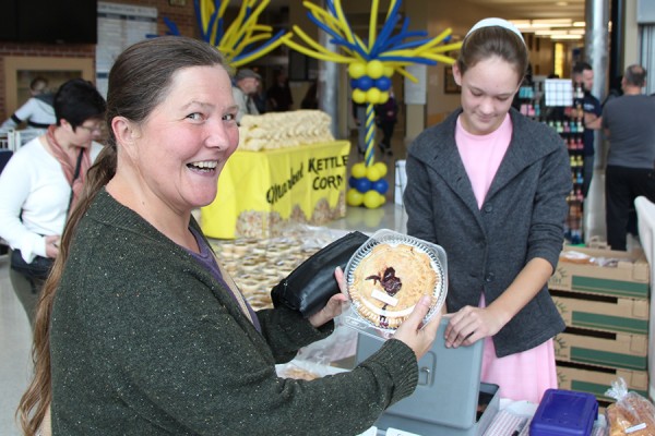 Agatha Knelsen, costume designer in the School of Dramatic Art, is delighted with her purchase of a cherry pie from the campus farmers market.