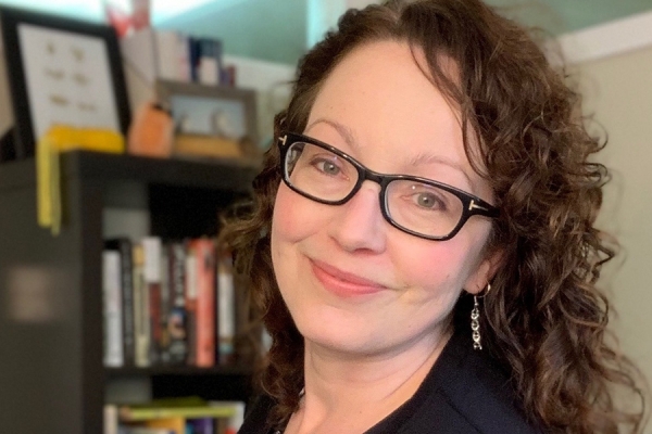 Tanya Noel: smiling woman with shelves of books in background