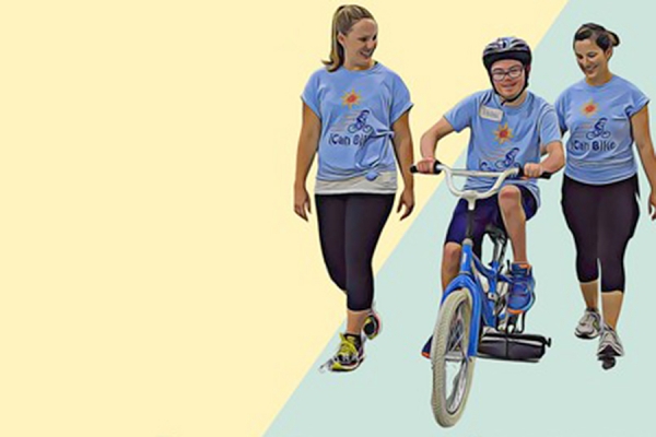 volunteer helpers walking alongside learning cyclist