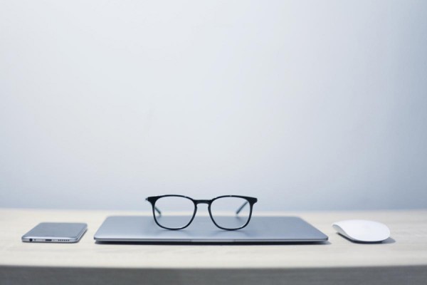 eyeglasses placed next to laptop computer