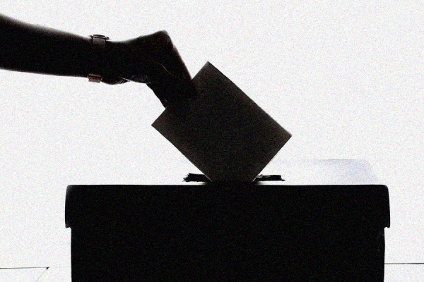 hand placing vote in ballot box