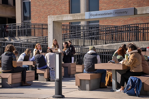 students gather in seating area on Turtle Island Walk