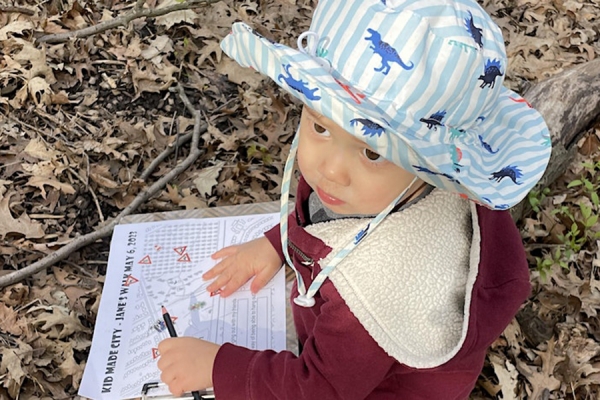 baby holding book titled Kid Made City