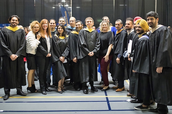 folks in grad robes posing for pictures