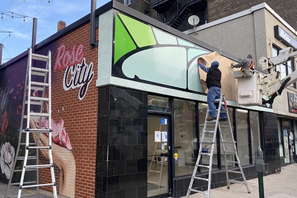 Workers install the new sign outside the BioArt Studio of professor Jennifer Willet.