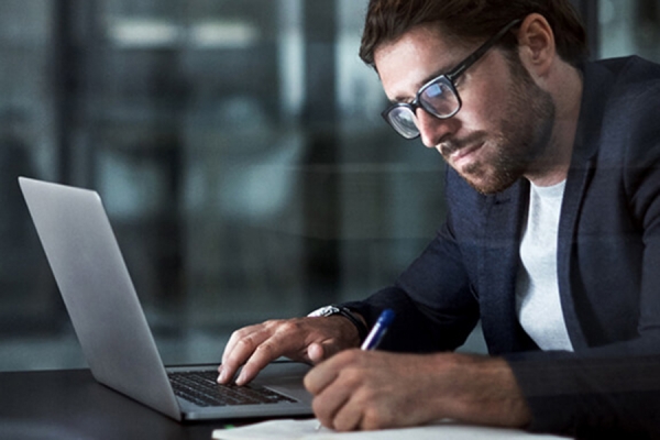 man bent over computer, presumably completing survey