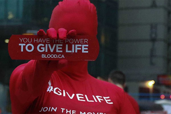 Person holding sign: You have the power to give life