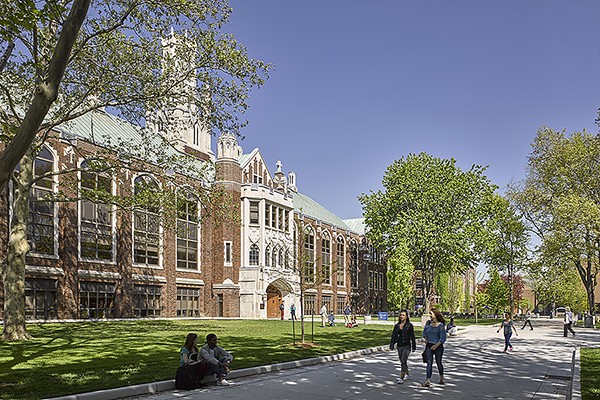 students stroll on sidewalk in front of Dillon Hall