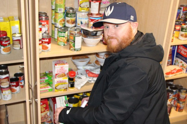 Chris Wainscott helps stock shelves in the Campus Food Bank