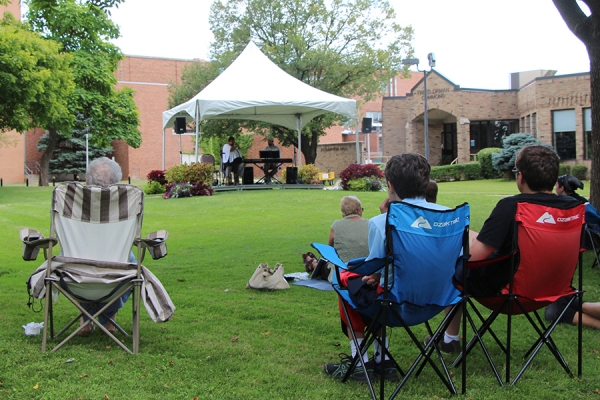 Shahida Nurullah and Mike Karloff performing before people on lawn chairs