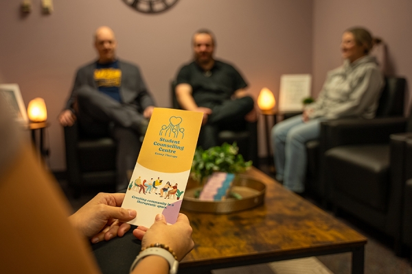 person holding brochure and leading counselling session