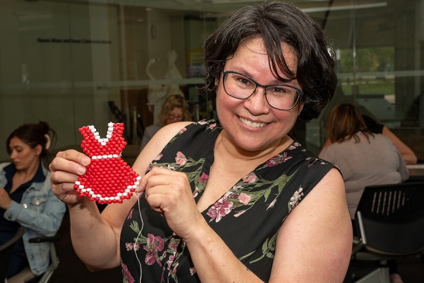 Giselle Aiabens holding beaded pin of red dress