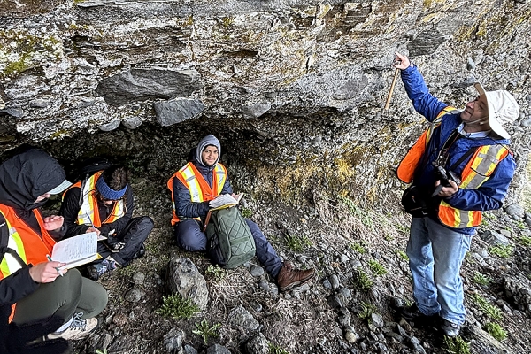 Geology professor Ali Polat points out features of rock structure to students