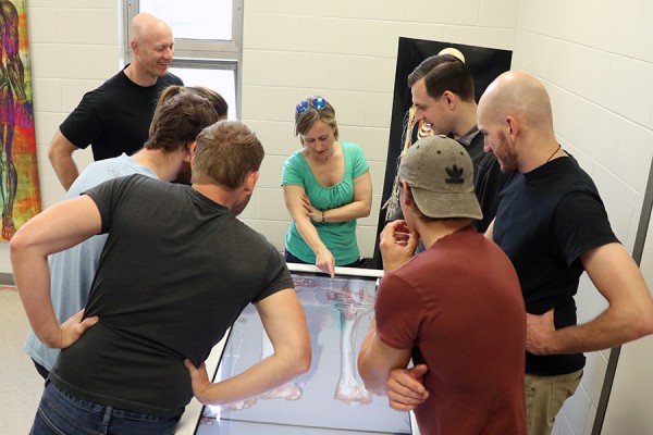 Human anatomy demonstrator Sara McNorton (centre) explains the virtual dissection table to medical staff of Cirque du Soleil.