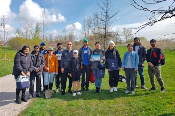 students, staff, and faculty planting trees