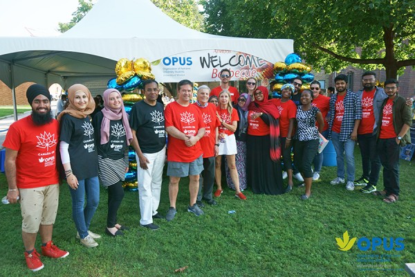 Staff and volunteers welcome guests to the annual Organization of Part-time University Students barbecue.