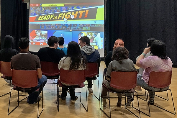 students playing video game on large projection screen