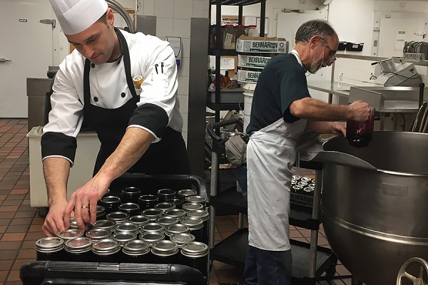 Paolo Vasapolli packs jars of jam being filled by Steve Daigle.