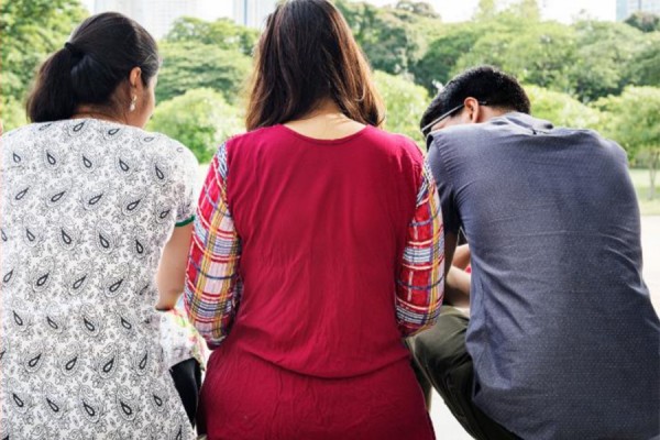 youths sitting with backs to viewer