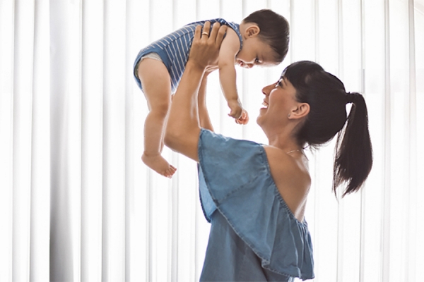 woman holding baby in air