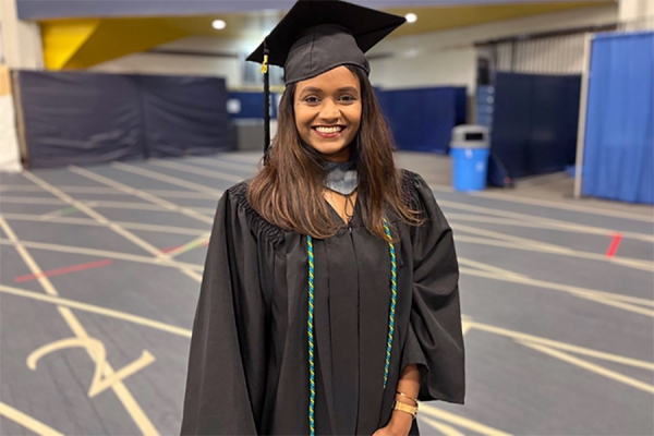 Grad with cap and gown and coloured cord