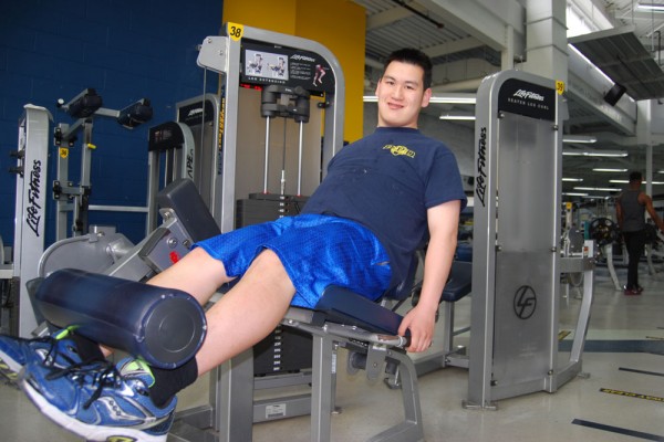 Robert Wilson performs a leg extension at the St. Denis Centre as part of the Adapted Physical Exercise (APEX) program coordinated by PhD student Kelly Carr in partnership with Community Living Essex County.