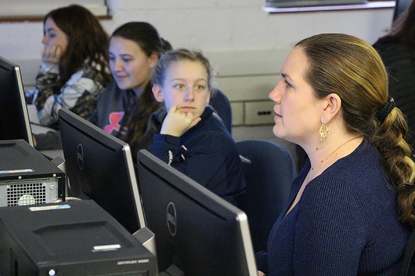 Alice Grgicak-Mannion sitting at computers with students