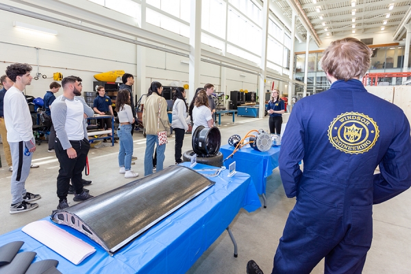 visitors listening to guide speak in engineering lab