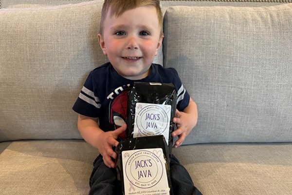 baby holding bags of coffee