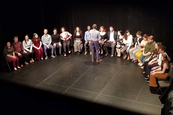 drama students sitting onstage