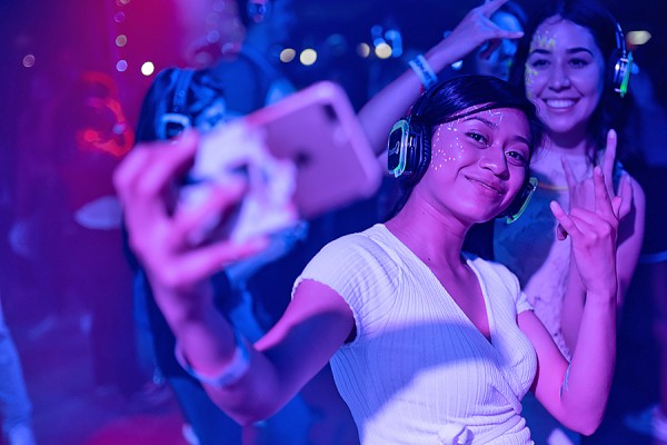 young people dancing under party lights