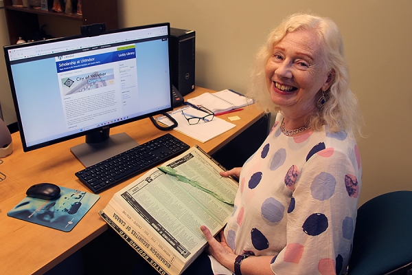 Katharine Ball holding a print copy of the city directory