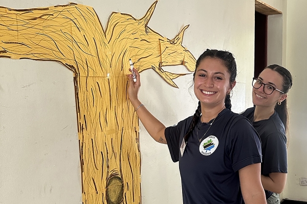 Gabriella Zagordo and Alyssa Miskov-Wilhelm paint tree on wall
