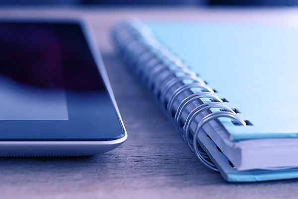 tablet computer and paper notebook