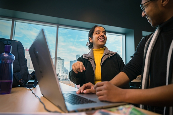 smiling students using computer