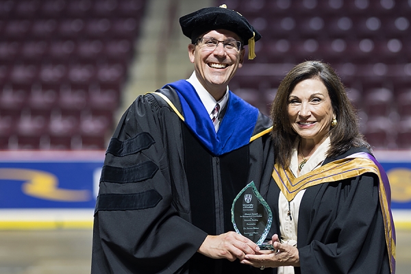 Steven Rehse receiving award trophy from Geri Salinitri