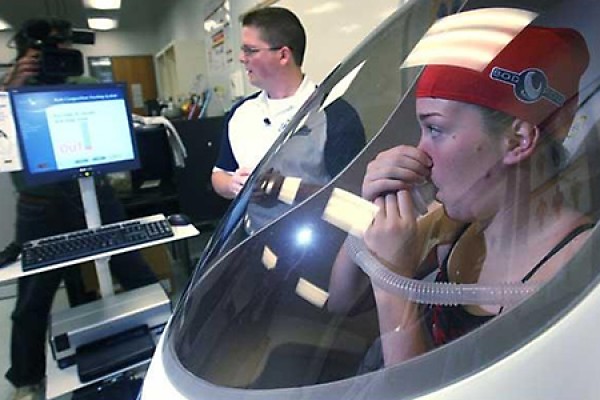 Chad Sutherland puts Milana McNamee through a body density test in the Bod Pod.