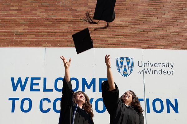 grads throwing mortarboard caps in air