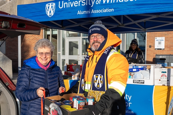 Susan McKee hands box of groceries to Michael Chantler