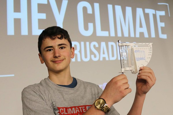 student holding up precipitation gauge