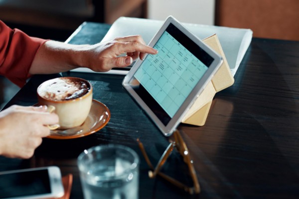 person consulting calendar on laptop computer