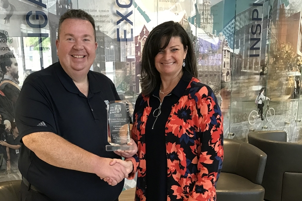 Alumni association president Gordon Orr shakes hand of Student Success and Leadership Centre director Cindy Crump.