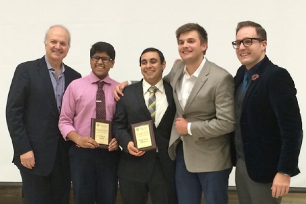 Business school officials congratulate the debate winners