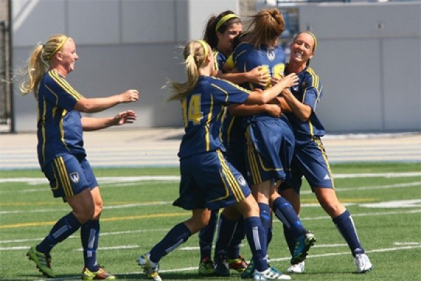 Lancer women’s soccer players hug and jump.